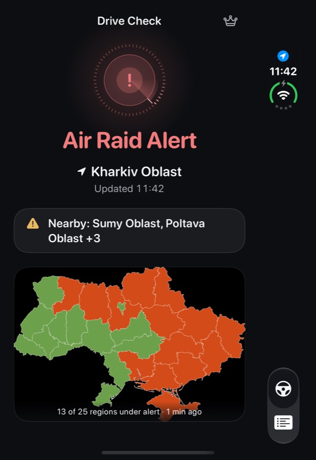 DriveCheckUA showing an air raid alert for Kharkiv Oblast with nearby regions and the alert map